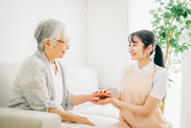 介護の現場で利用者の手を取り、笑顔で向き合う様子